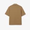 Polo oversize en satin rehaussé d’un badge Runway Polo oversize en satin rehaussé d’un badge Runway